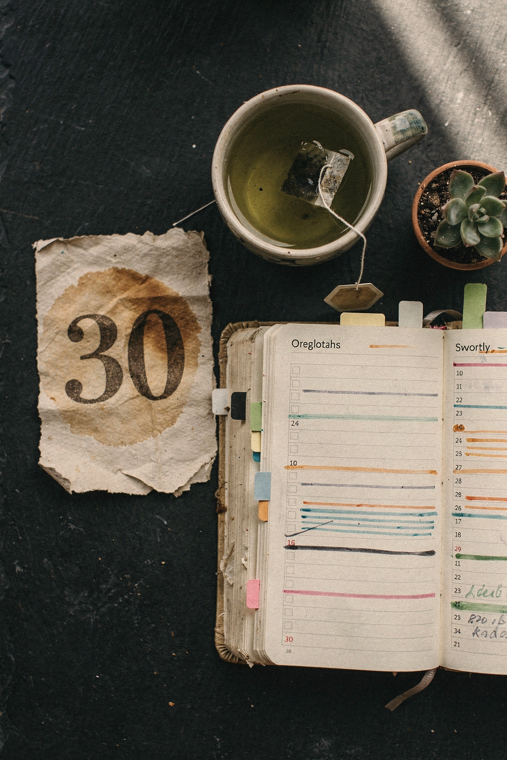 Crumpled calendar page showing day 30 next to a well-used planner with months of highlighted entries